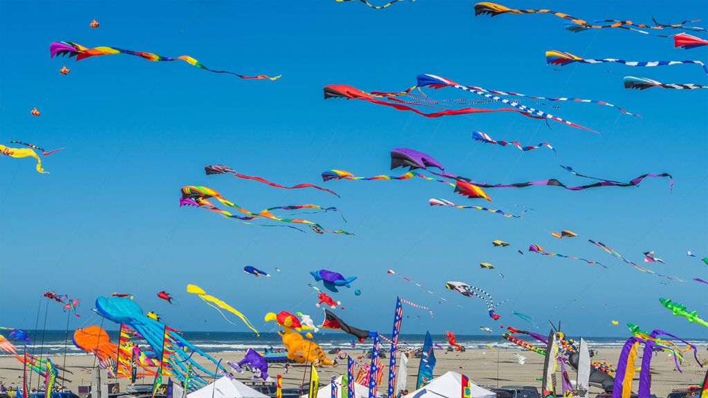 A view of the Treasure Island Kite Festival. Dozens of colorful kites soaring high in sky above the waters of Treasure Island Beach.